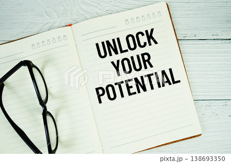 Notepad with message "Unlock Your Potential" and eyeglass on wooden background Notepad with message "Unlock Your Potential" and eyeglass on wooden background 138693350