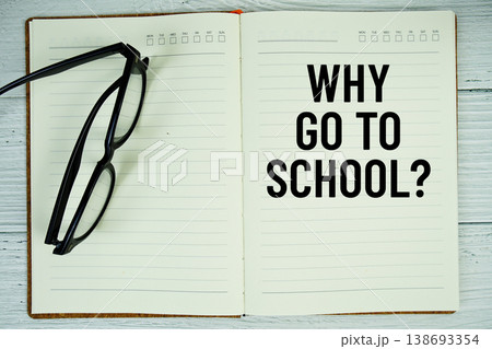 Notepad with message "Why Go To School?" and eyeglass on wooden background Notepad with message "Why Go To School?" and eyeglass on wooden background 138693354