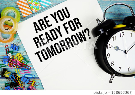 Are You Ready For Tomorrow? text with alarm clock and colorful office supplies on a blue wooden surface Are You Ready For Tomorrow? text with alarm clock and colorful office supplies on a blue wooden surface 138693367