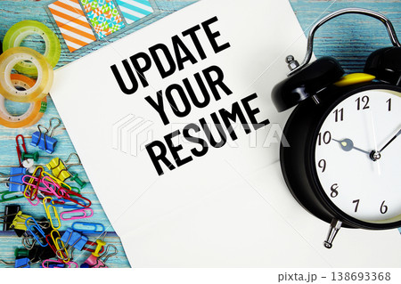 Update Your Resume text on a paper surrounded by office supplies and a clock on a blue wooden surface 138693368