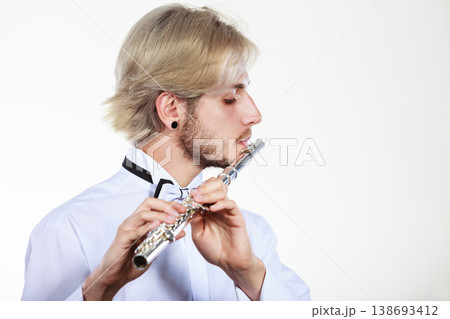 Male flutist playing his flute 138693412