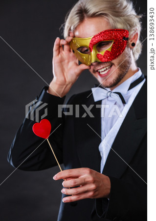 Man in carnival mask with heart stick love symbol 138693430