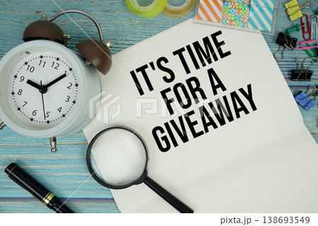 It's Time For A Giveaway text written on notepad with alarm clock and magnifying glass flat lay on wooden background 138693549