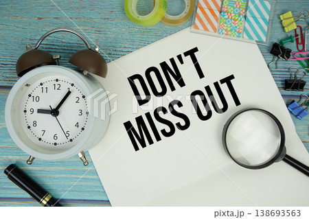 Don't Miss Out text written on notepad with alarm clock and magnifying glass flat lay on wooden background Don't Miss Out text written on notepad with alarm clock and magnifying glass flat lay on wooden background 138693563