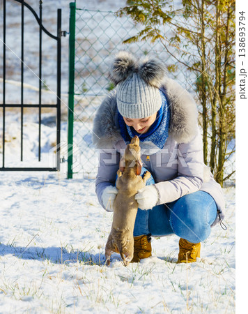 Woman playing with dog during winter Woman playing with dog during winter 138693794