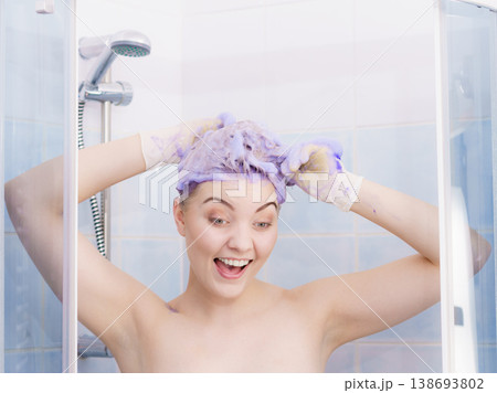 Woman applying toner shampoo on her hair Woman applying toner shampoo on her hair 138693802