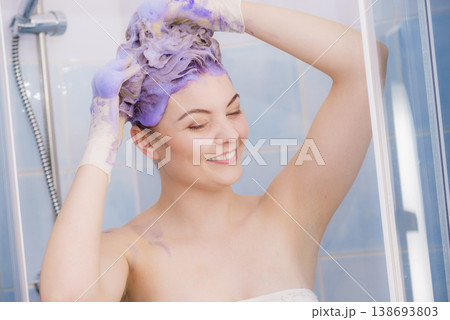 Woman applying toner shampoo on her hair Woman applying toner shampoo on her hair 138693803