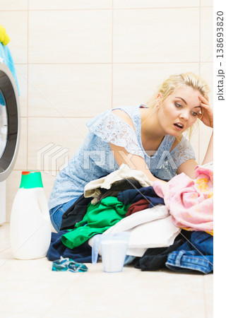 Unhappy woman having a lot of laundry Unhappy woman having a lot of laundry 138693820