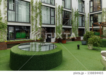 Tranquil urban sanctuary featuring lush plants and reflective surfaces Tranquil urban sanctuary featuring lush plants and reflective surfaces 138694403