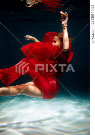 Underwater shot showing woman in red dress with strong contrast Underwater shot showing woman in red dress with strong contrast 138694415