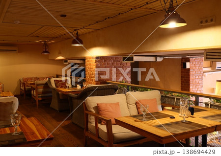 Spacious loft with communal tables and warm workspace ambiance 138694429