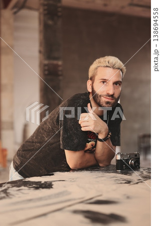 Sunkissed Caucasian male in introspective pose with camera on ground Sunkissed Caucasian male in introspective pose with camera on ground 138694558