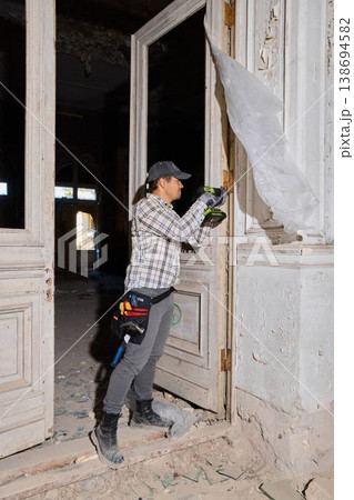 Caucasian restorer opening boarded doorway during survey 138694582