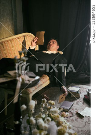 Detective in dim room. Seated investigator assesses evidence amidst shadows 138694655