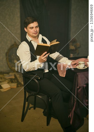 Young Caucasian man engaged with vintage books under warm lighting Young Caucasian man engaged with vintage books under warm lighting 138694669