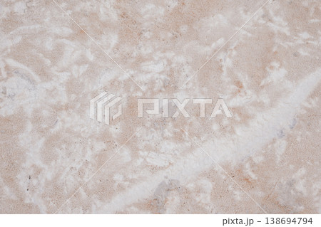 Close-up of natural stone texture with coral and ginger orange tones. Rough rocky surface pattern 138694794