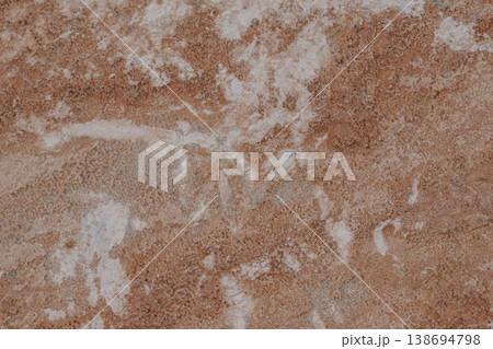 Close-up of natural stone texture with coral and ginger orange tones. Rough rocky surface pattern 138694798
