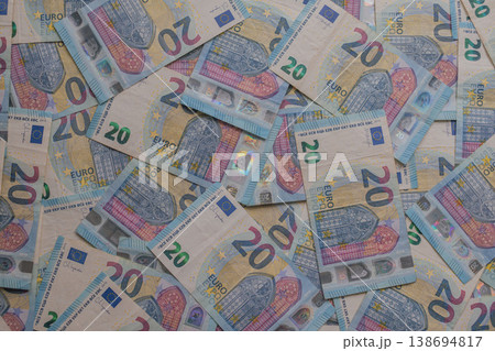 Dense texture of 20 Euro banknotes in a dynamic arrangement. Detailed macro shot of blue European currency featuring holograms and watermarks. Financial abundance concept Dense texture of 20 Euro banknotes in a dynamic arrangement. Detailed macro shot of blue European currency featuring holograms and watermarks. Financial abundance concept 138694817