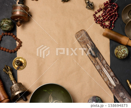 Religious objects for prayer and meditation, with a sheet of brown paper in the middle for writing. Top view. 138694873