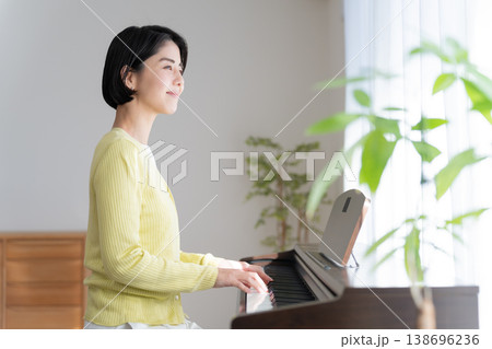 家で電子ピアノを弾く女性 138696236