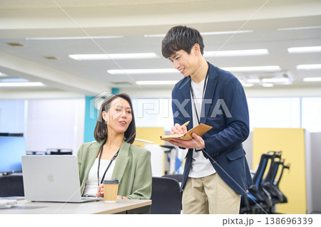 メモを取る後輩エンジニアに開発要件を指示する女性システムエンジニア メモを取る後輩エンジニアに開発要件を指示する女性システムエンジニア 138696339