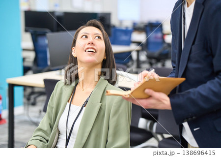 メモを取る後輩エンジニアに開発要件を指示する女性システムエンジニア メモを取る後輩エンジニアに開発要件を指示する女性システムエンジニア 138696415