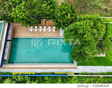 Swimming pool blue water and green grass in summer top view angle. Aerial view images of swimming pool in a sunny day Swimming pool blue water and green grass in summer top view angle. Aerial view images of swimming pool in a sunny day 138696494