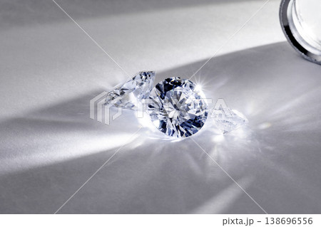 brilliant cut diamond held by tweezers on white background 138696556