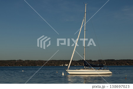 White sailboat moored on calm blue lake under clear sky White sailboat moored on calm blue lake under clear sky 138697023