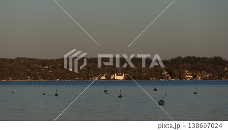 Calm lake water with mooring buoys and distant shoreline Calm lake water with mooring buoys and distant shoreline 138697024