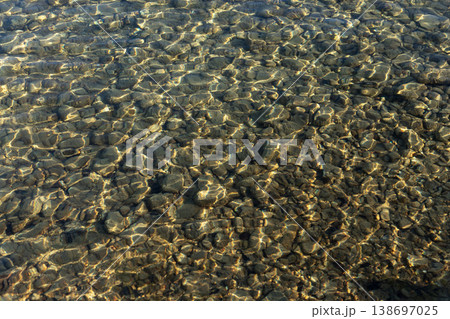 Clear water ripples over pebbles texture background 138697025