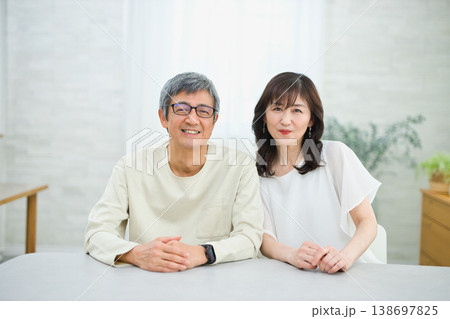 リビングで楽しく会話する60代の夫婦 リビングで楽しく会話する60代の夫婦 138697825