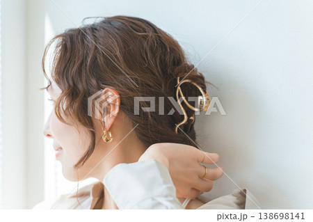 ゴールドのヘアアクセサリーでまとめ髪,ヘアアレンジをする女性 ゴールドのヘアアクセサリーでまとめ髪,ヘアアレンジをする女性 138698141