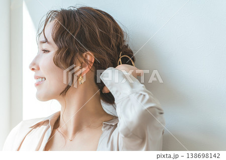 ゴールドのヘアアクセサリーでまとめ髪,ヘアアレンジをする女性 ゴールドのヘアアクセサリーでまとめ髪,ヘアアレンジをする女性 138698142