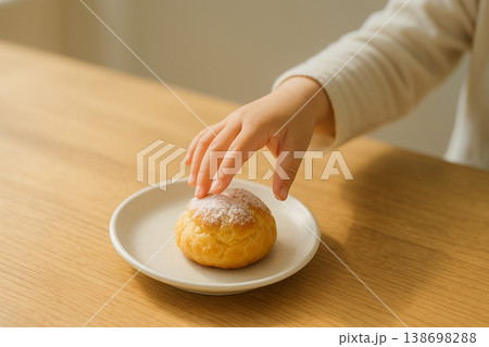 シュークリームに手を伸ばす子供 シュークリームに手を伸ばす子供 138698288