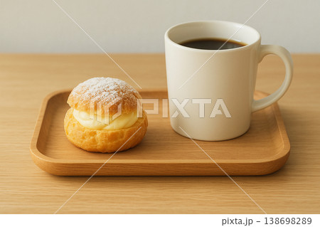 テーブルの上に置かれたシュークリームとコーヒー 138698289