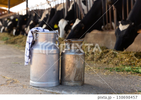 Image of two milk canisters standing on a farm 138698457
