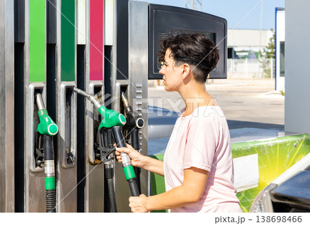 Smiling woman refueling her car in gas station Smiling woman refueling her car in gas station 138698466