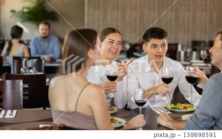 Two couples meet for dinner at restaurant. They chat and drink wine Two couples meet for dinner at restaurant. They chat and drink wine 138698591
