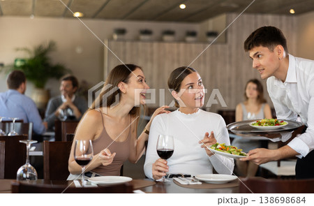 Waiter brings order to couple of women Waiter brings order to couple of women 138698684