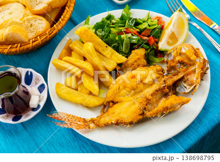 Fried lionfish served on white plate with vegetable garnish Fried lionfish served on white plate with vegetable garnish 138698795