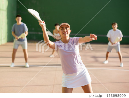 Young Argentinian woman playing pelota at open-air fronton in summer 138698909