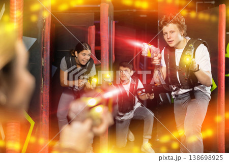 Three people having fun playing lasertag in arena 138698925