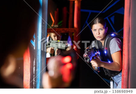 Girl running and dodging while playing lasertag 138698949