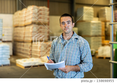 Man checking documentation in warehouse Man checking documentation in warehouse 138698955