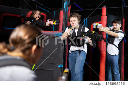 Three people having fun playing lasertag in arena 138698956