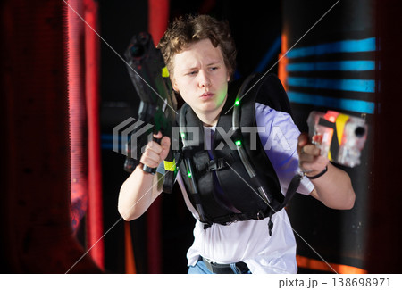 Portrait of man with laser gun having fun with family on laser tag arena Portrait of man with laser gun having fun with family on laser tag arena 138698971