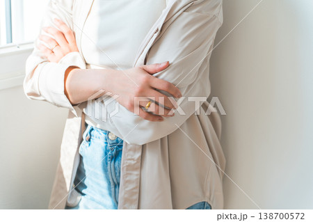 家の窓際で腕組みをする悩む,考える女性 家の窓際で腕組みをする悩む,考える女性 138700572
