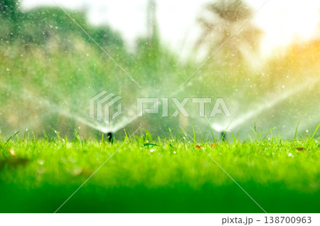Automatic lawn sprinkler watering green grass. Sprinkler with automatic system. Garden irrigation system watering lawn. Water saving or water conservation from sprinkler system with adjustable head. 138700963