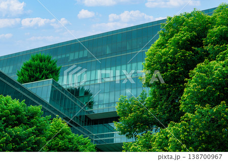 Eco-friendly building in the modern city. Sustainable glass office building with trees for reducing heat and carbon dioxide. Office building with green environment. Corporate building reduce CO2. 138700967
